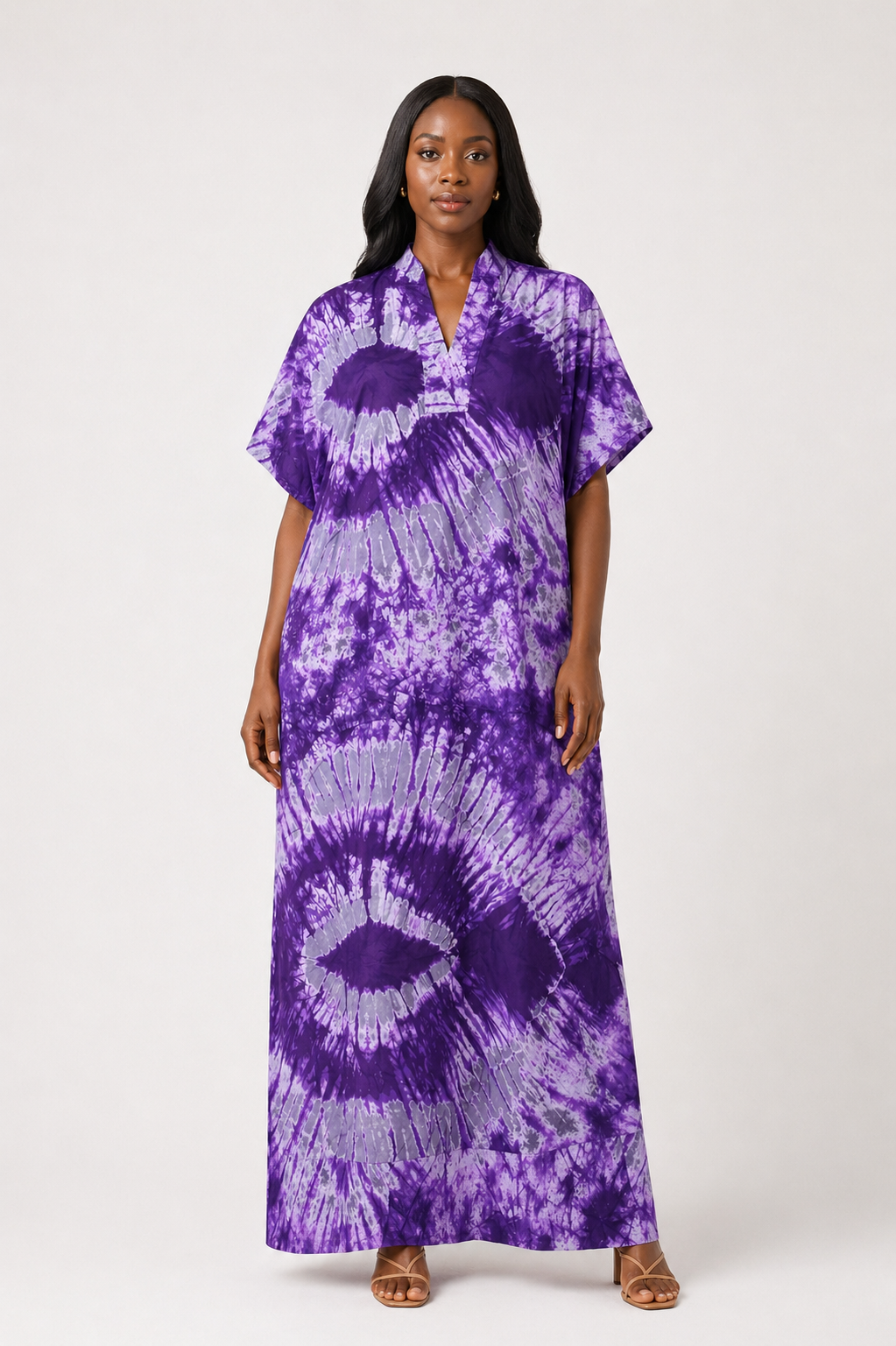 Woman wearing a purple tie-dye dress on a white background