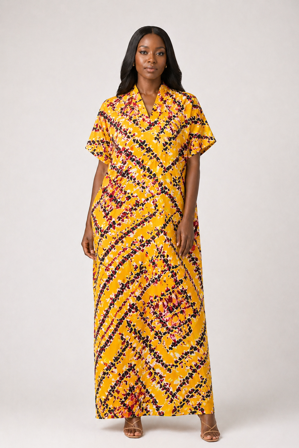 Woman wearing a yellow patterned dress on a white background